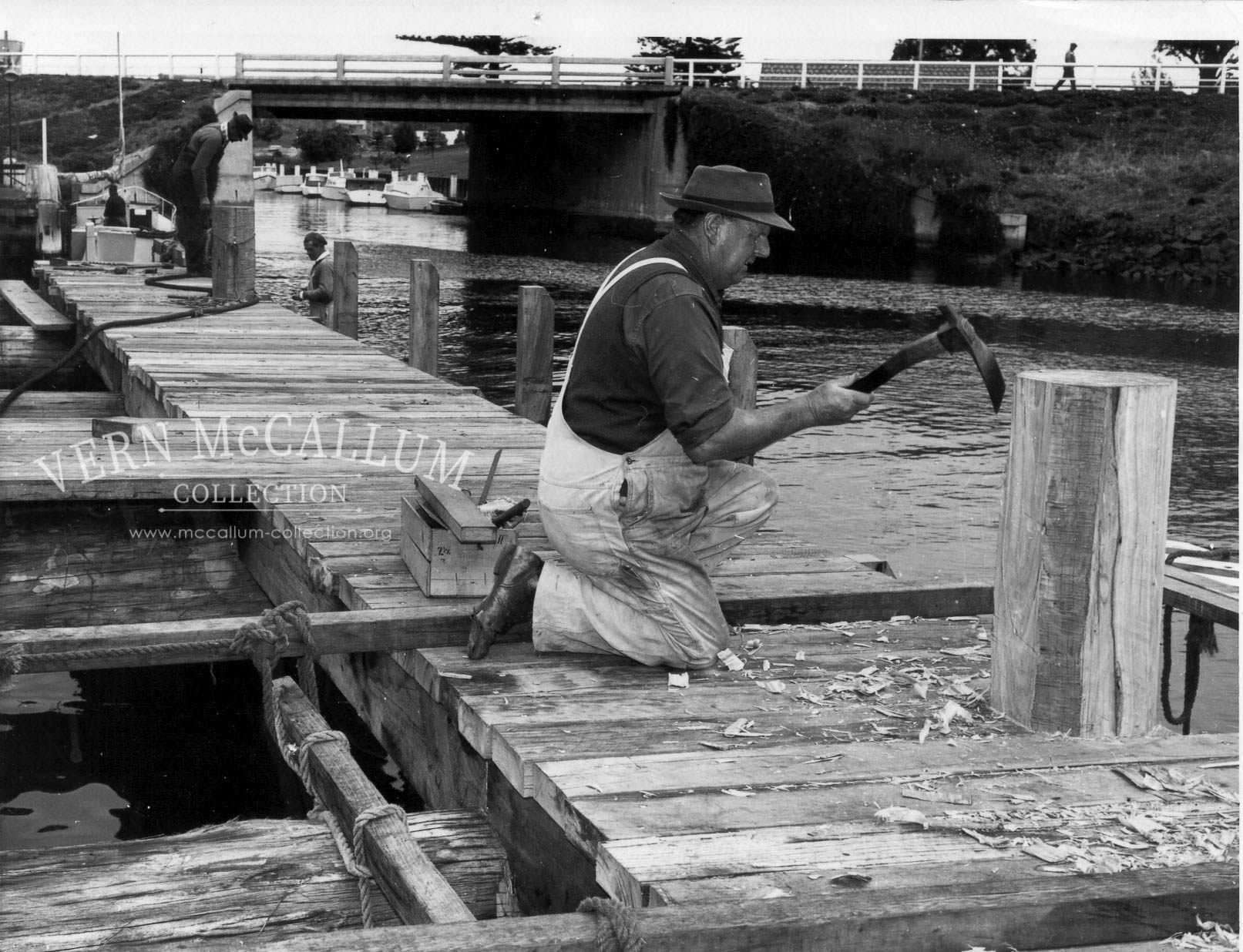 Building the pier on the canel,Kelly Smith shaping a bollard on the fisherman's jetty using an adze ,Portland.