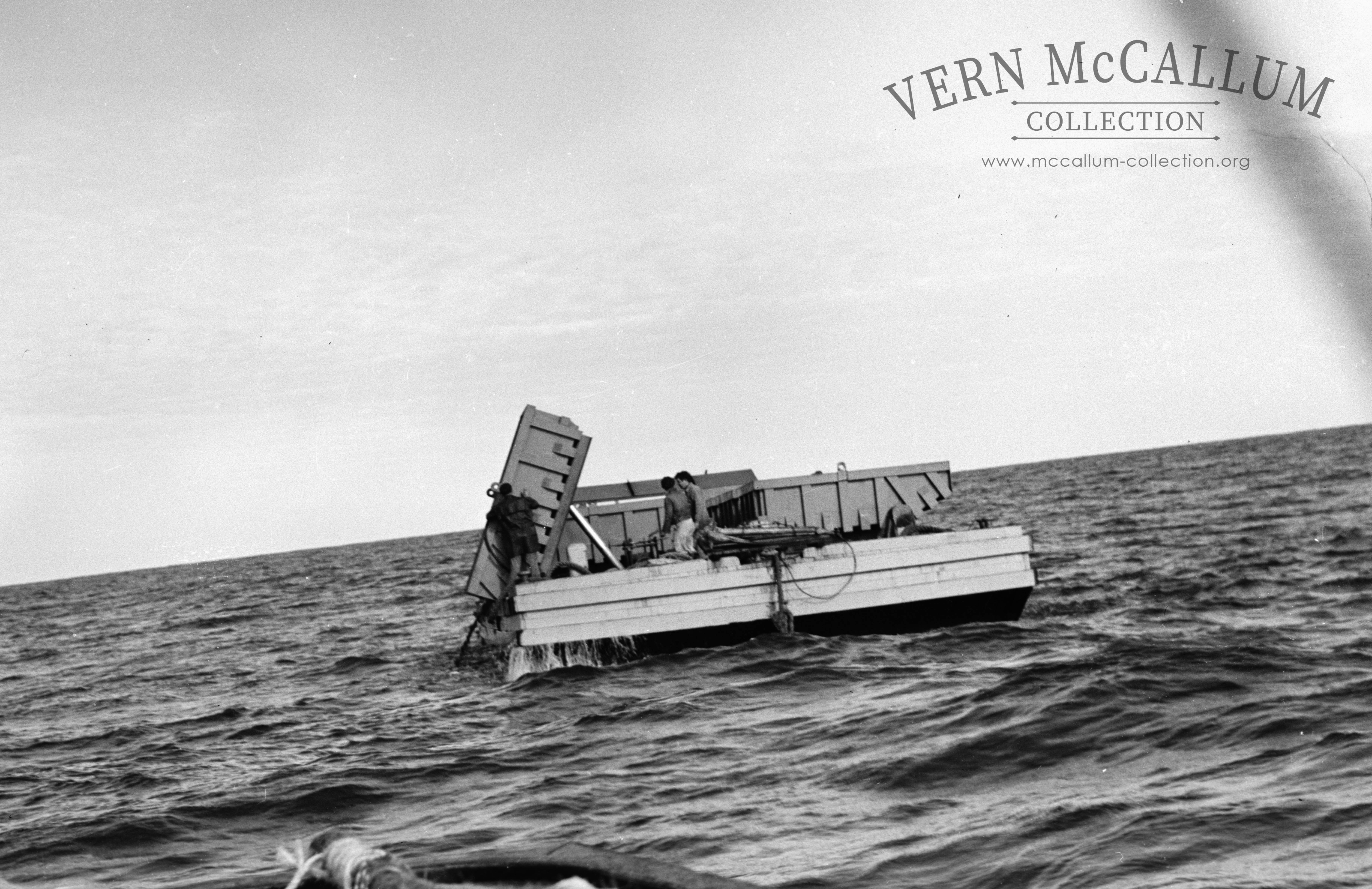 Unloading the barge at sea. When the barge had been loaded by the dredge it was taken out to sea and dumped in the deep water. The fill had been dredged from the K.S. Anderson wharf area.