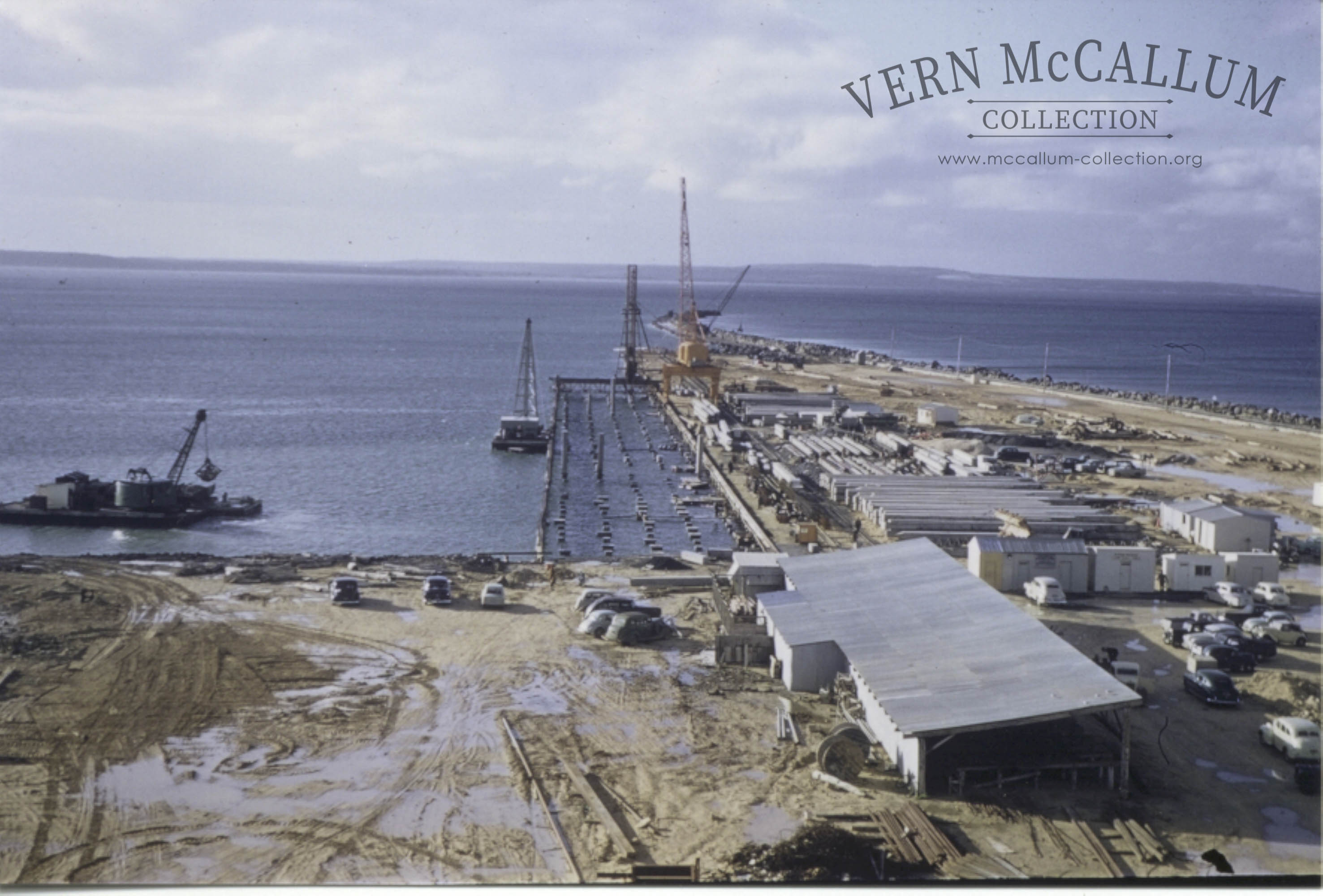 A view of the early part of the construction of the K. S. Anderson wharf with the Priestman Dredge and barge in the foreground ( called Elders Island}}.