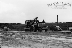 Jaques Shovel on a multi,wheel trailer being towed behind a Euclid truck.