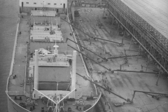 A ship loading grain at Portland . Augering oats from transit shed to ship.