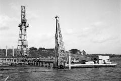 The Port pile driver driving piles for Hornibrooks pile driver.The rails for hornibrooks crane was placed on these timber piles that were cut off after the wharf had been constructed.