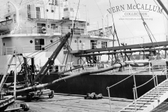 A ship tied up on the ocean pier. Unloading fuel.
